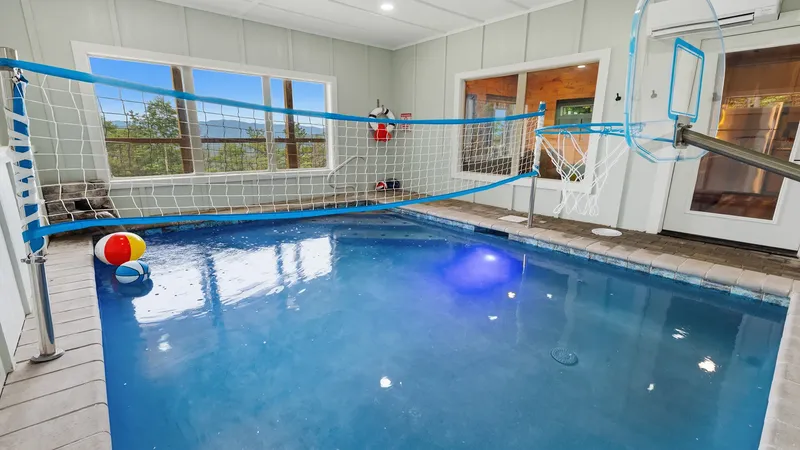 Private indoor pool with basketball hoop and volleyball net